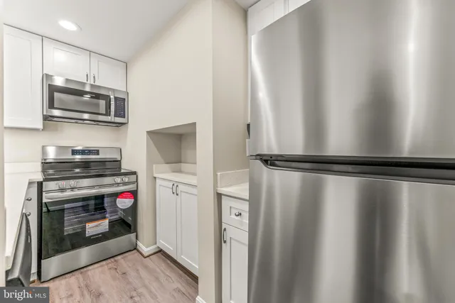 a kitchen with stainless steel appliances a refrigerator and a stove top oven