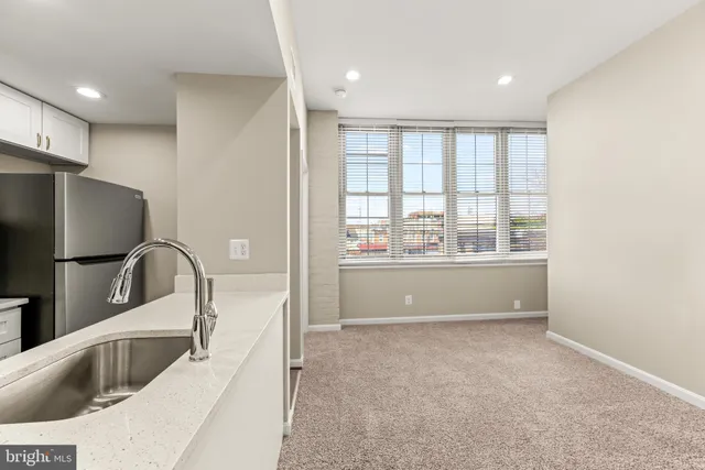 a view of kitchen with a sink a refrigerator and window