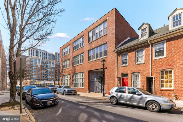a car parked in front of a building and cars parked
