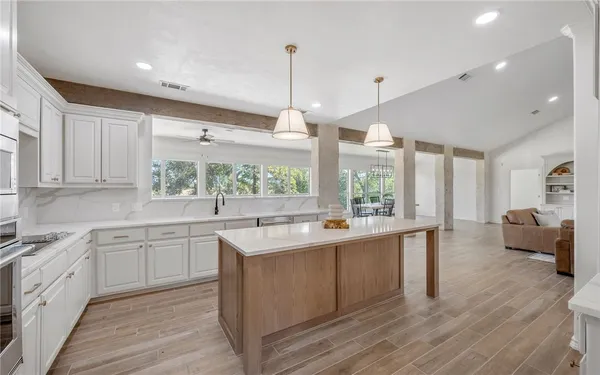 a open kitchen with stainless steel appliances granite countertop a sink a stove and wooden floor
