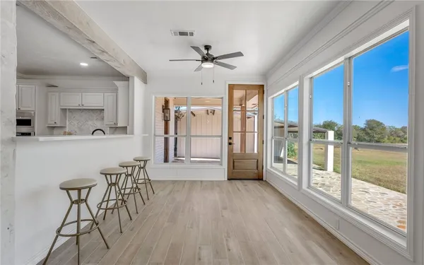 a living room with stainless steel appliances granite countertop furniture wooden floor and a large window