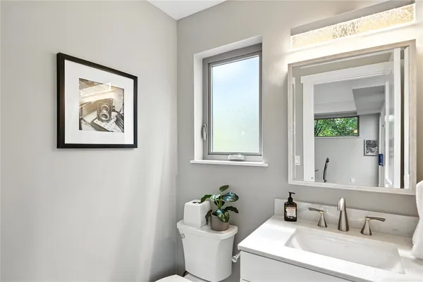 a bathroom with a toilet a sink and mirror