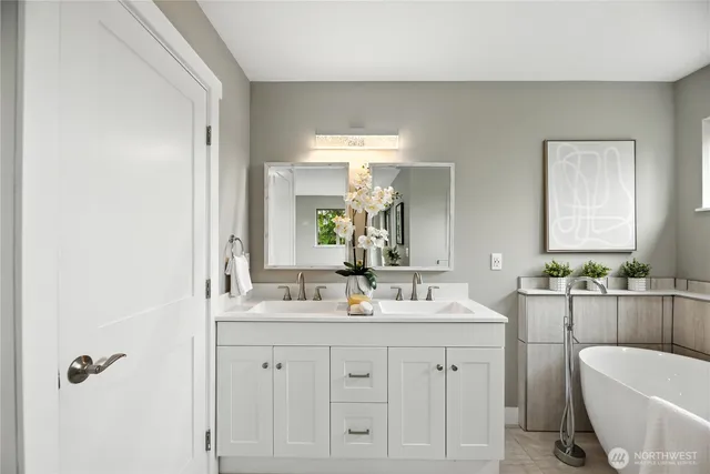 a bathroom with a double vanity sink a mirror and a bathtub
