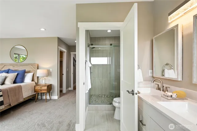 a en suite bathroom with a double vanity sink a mirror and a shower