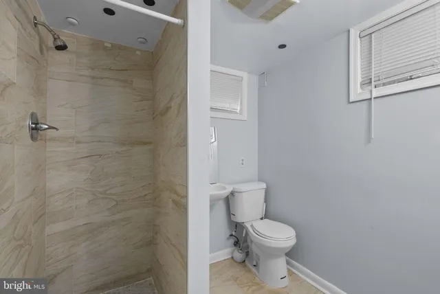 a white toilet sitting next to a bathroom sink