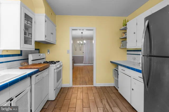 a kitchen with a sink a refrigerator a stove and wooden floor