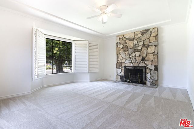 an empty room with windows and fireplace