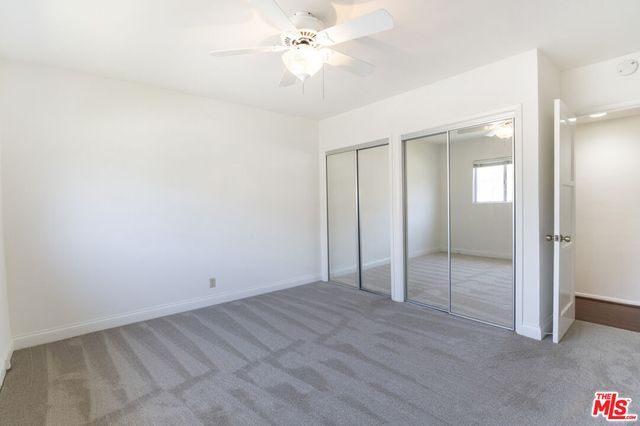 an empty room with fan and entryway