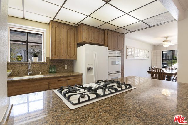 a kitchen with stainless steel appliances a stove a sink and a refrigerator