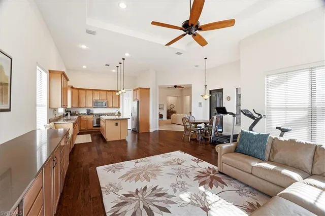 a living room with furniture kitchen view and a large window