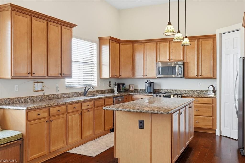 5149 Roma Street Ave Maria, FL 34142 - Photo 18 of 50 a kitchen with stainless steel appliances granite countertop a sink stove and cabinets