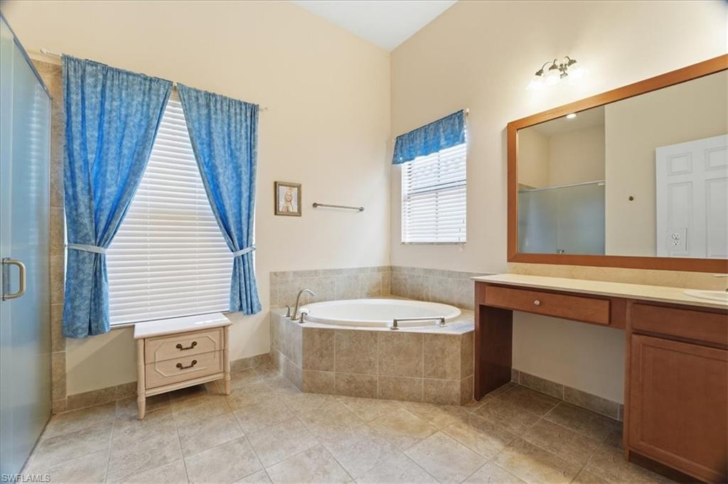 5149 Roma Street Ave Maria, FL 34142 - Photo 25 of 50 a bathroom with a tub a sink a mirror and a bathtub