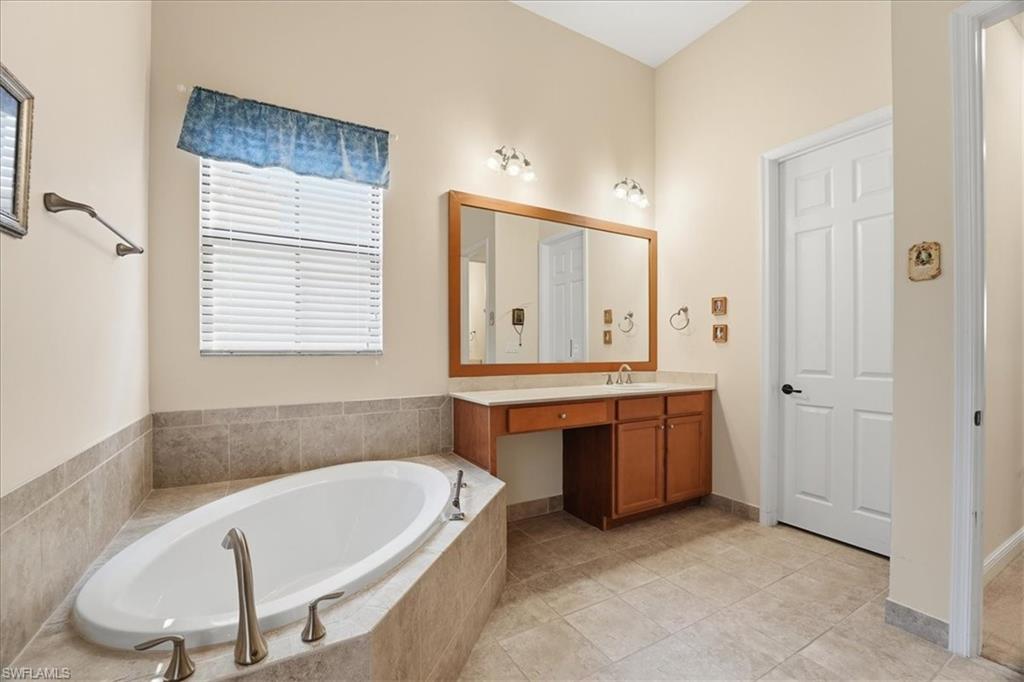 5149 Roma Street Ave Maria, FL 34142 - Photo 26 of 50 a bathroom with a tub a sink and a mirror