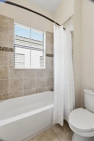 a white toilet sitting next to a bath tub