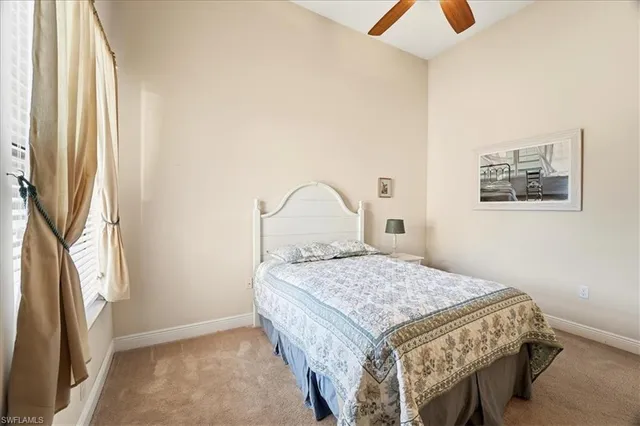 a bedroom with a bed and a dresser next to a window