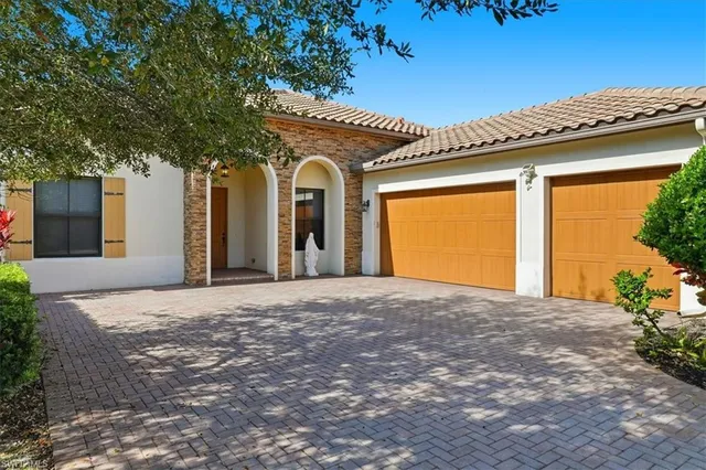 a view of a house with a patio and a yard