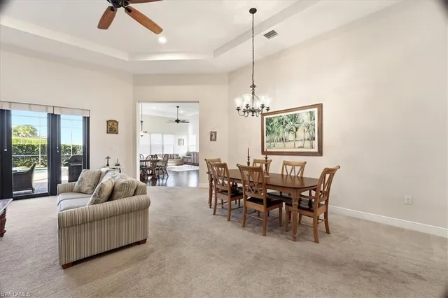 a living room with furniture a dining table and a chandelier
