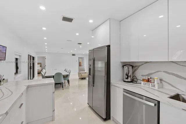 a kitchen with granite countertop a sink stainless steel appliances and cabinets