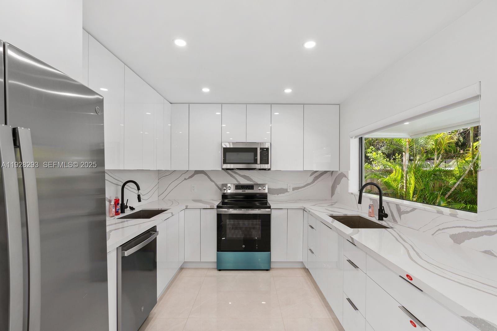 965 Northeast 171 Street Miami, FL 33162 - Photo 17 of 29 a kitchen with granite countertop a sink stainless steel appliances and cabinets