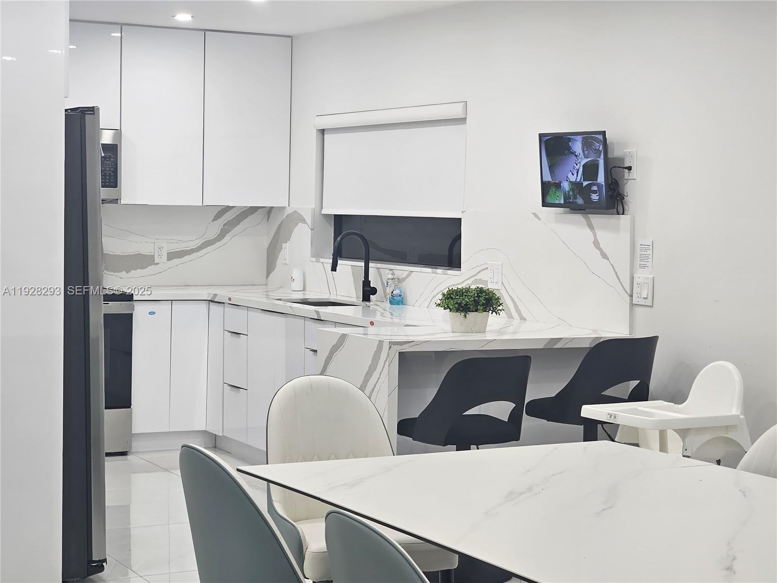 965 Northeast 171 Street Miami, FL 33162 - Photo 18 of 29 a close view of dining table chairs and a refrigerator