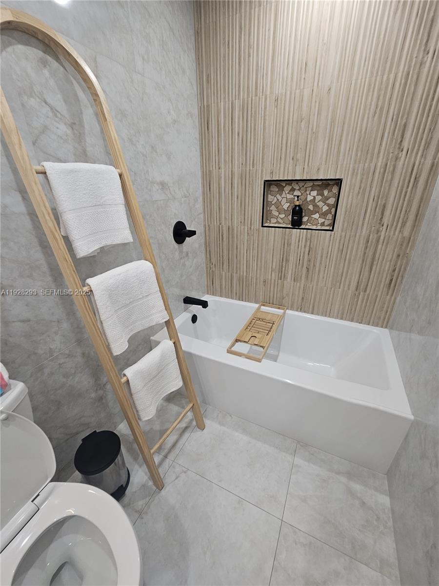 965 Northeast 171 Street Miami, FL 33162 - Photo 23 of 29 a bathroom with a bathtub and shower