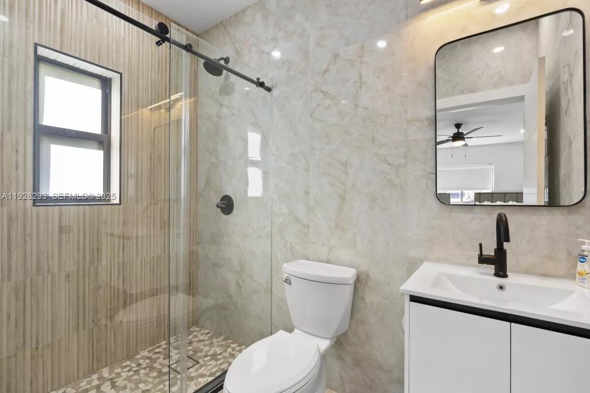 965 Northeast 171 Street Miami, FL 33162 - Photo 25 of 29 a bathroom with a granite countertop sink toilet and shower
