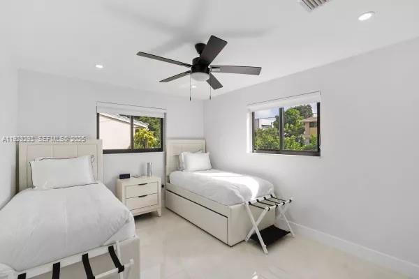 965 Northeast 171 Street Miami, FL 33162 - Photo 26 of 29 a bedroom with a bed and a chandelier