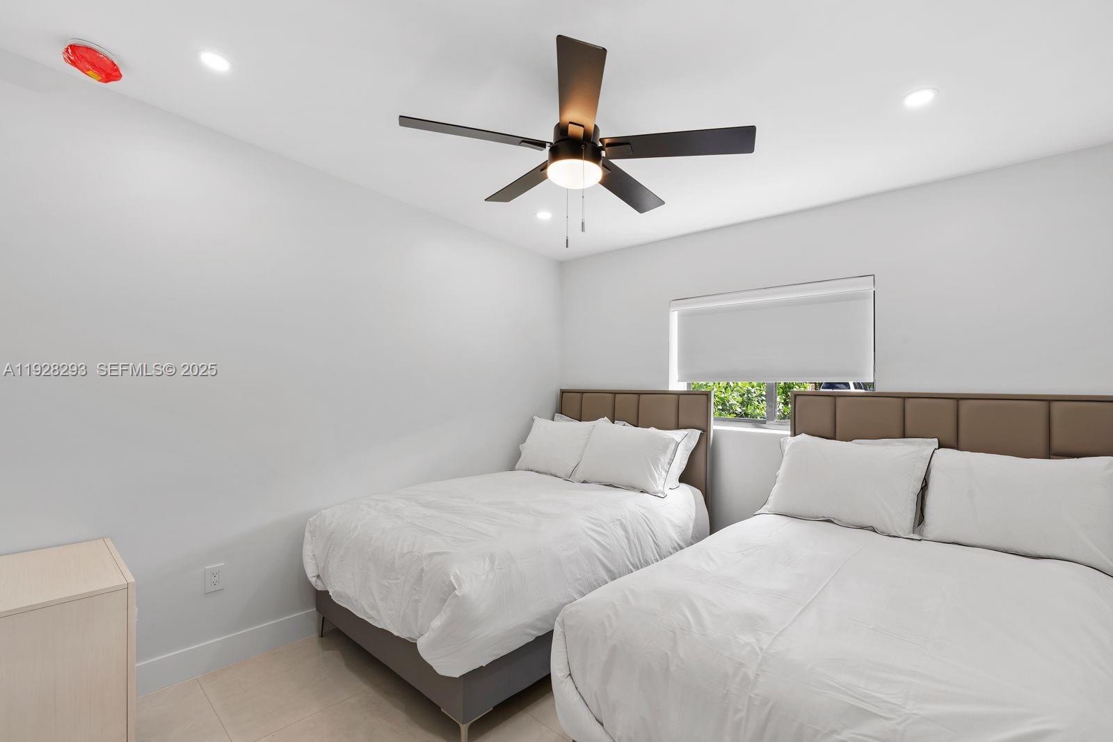 965 Northeast 171 Street Miami, FL 33162 - Photo 28 of 29 a large bedroom with a bed and a ceiling fan
