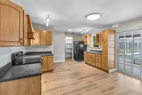a kitchen with kitchen island granite countertop a sink stove and refrigerator
