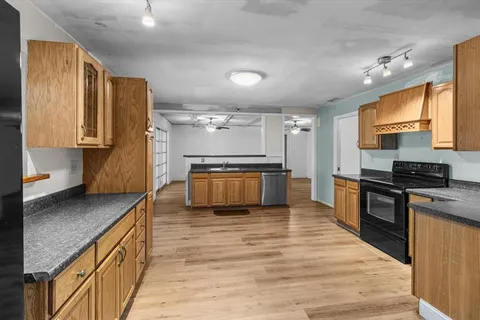 a kitchen with stainless steel appliances granite countertop a stove a sink and a refrigerator