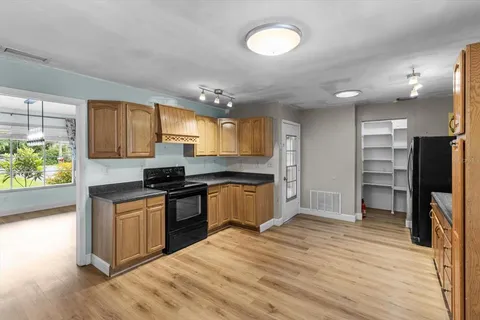 an empty room with windows and chandelier fan