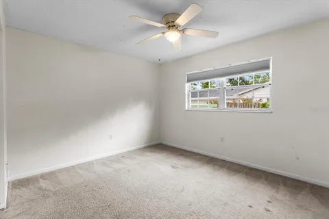 an empty room with closet and a ceiling fan