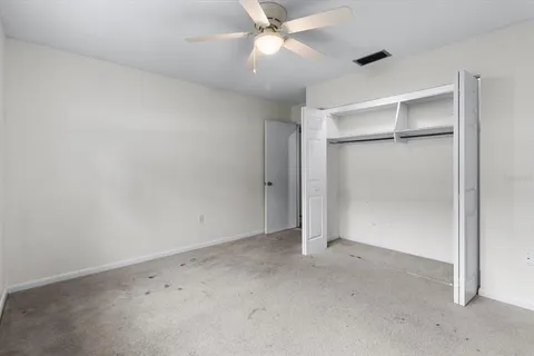 an empty room with a window and a ceiling fan