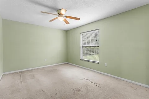 an empty room with chandelier fan