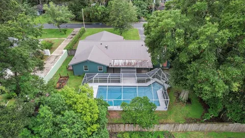 an aerial view of a house with a yard and large trees
