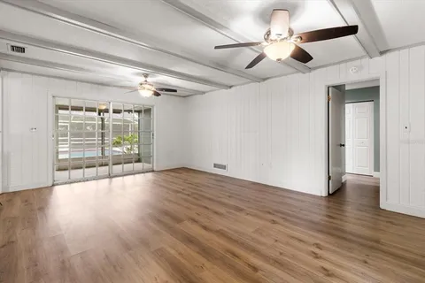 a view of an empty room with wooden floor