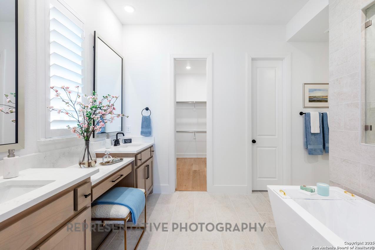 4412 Wendell Way Schertz, TX 78108 - Photo 15 of 28 a en suite bathroom with a granite countertop sink and a bathtub