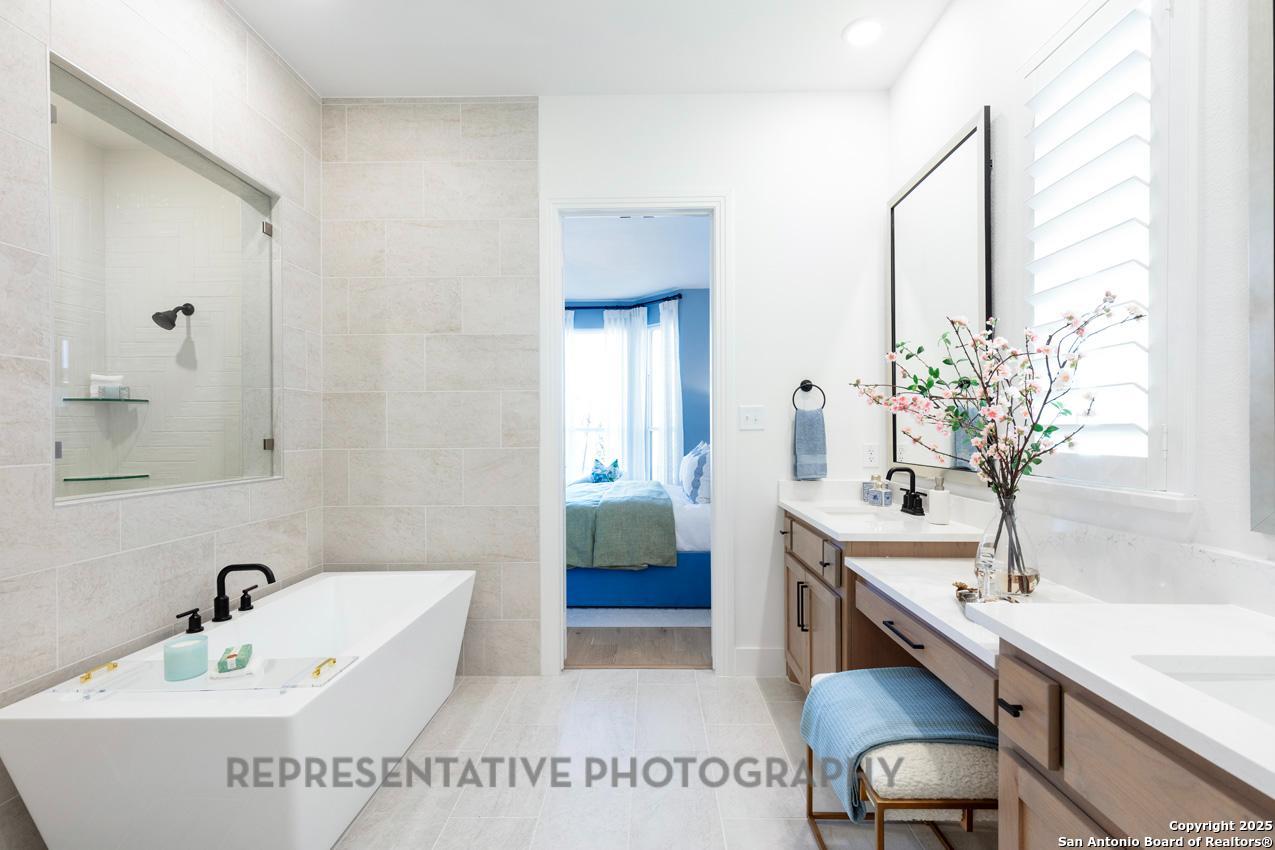 4412 Wendell Way Schertz, TX 78108 - Photo 18 of 28 a spacious bathroom with a double vanity sink and a bathtub
