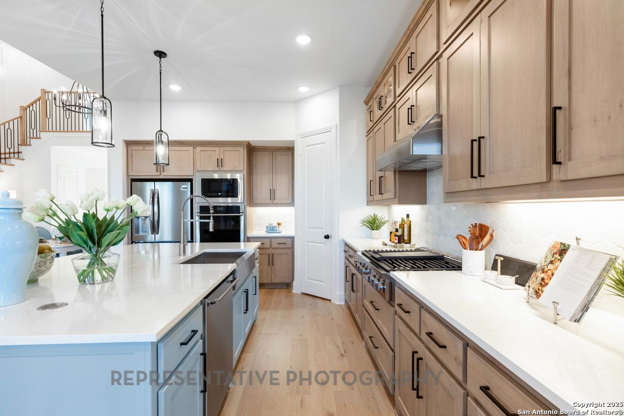4412 Wendell Way Schertz, TX 78108 - Photo 4 of 28 a kitchen with granite countertop a sink a counter space appliances and cabinets