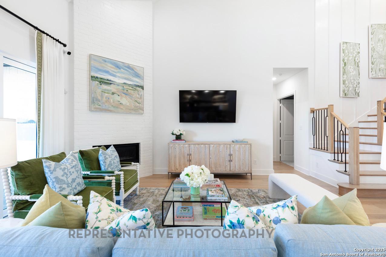 4412 Wendell Way Schertz, TX 78108 - Photo 9 of 28 a living room with furniture a flat screen tv and a fireplace