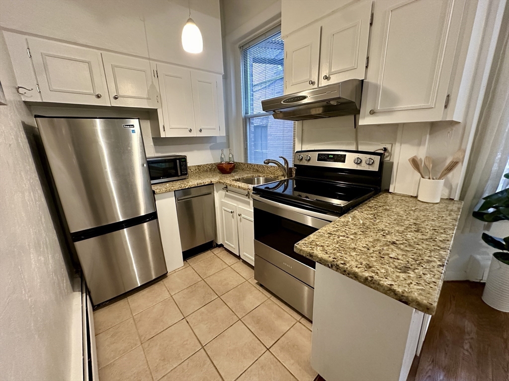 30 Pinckney Street, Unit 2 Boston, MA 02114 - Photo 1 of 18 a kitchen with stainless steel appliances granite countertop a stove a refrigerator and a microwave