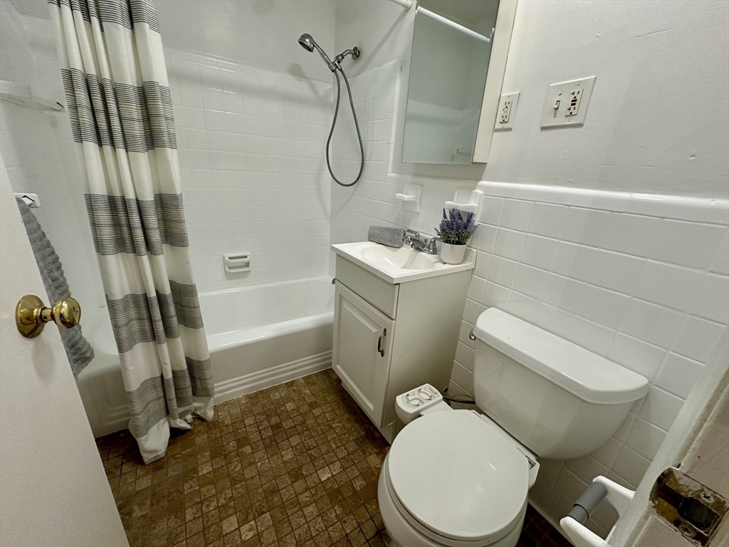 30 Pinckney Street, Unit 2 Boston, MA 02114 - Photo 14 of 18 a white toilet sitting next to a bath tub and shower