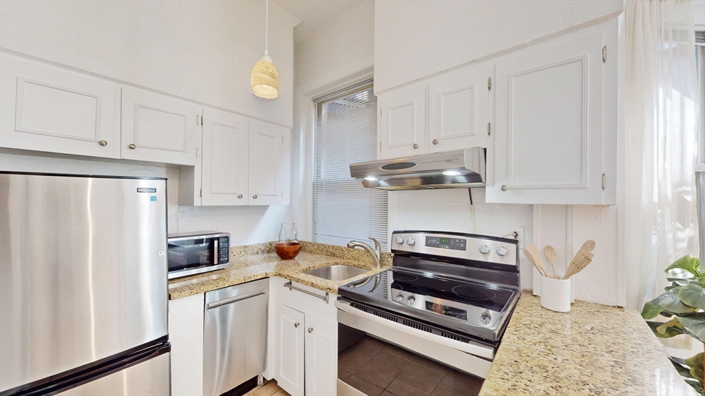 30 Pinckney Street, Unit 2 Boston, MA 02114 - Photo 3 of 18 a kitchen with stainless steel appliances white cabinets and a refrigerator