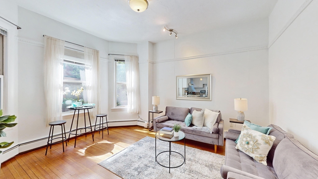 30 Pinckney Street, Unit 2 Boston, MA 02114 - Photo 6 of 18 a living room with furniture and a table with wooden floor