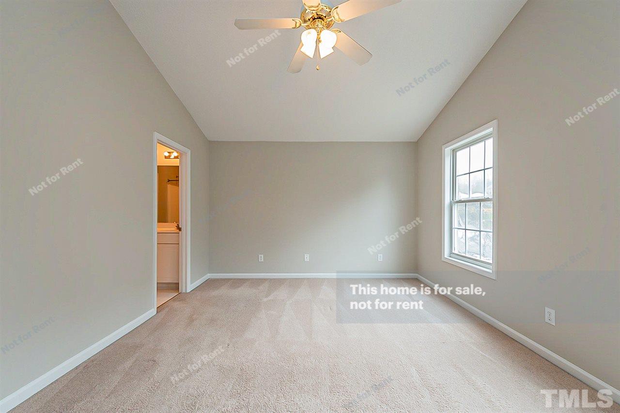 8715 Harps Mill Road Raleigh, NC 27615 - Photo 14 of 22 an empty room with windows and ceiling fan