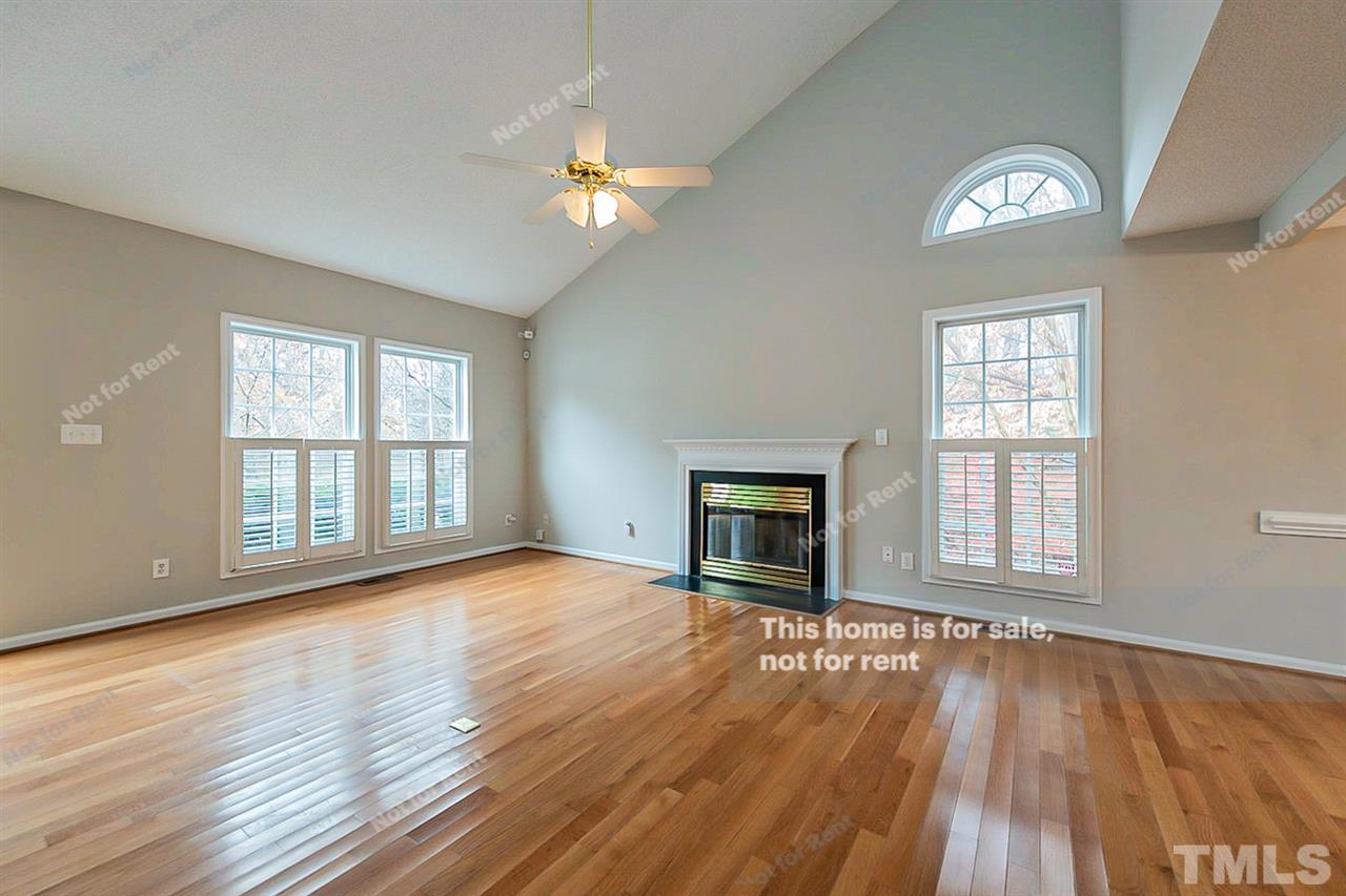 8715 Harps Mill Road Raleigh, NC 27615 - Photo 3 of 22 an empty room with wooden floor chandelier and windows