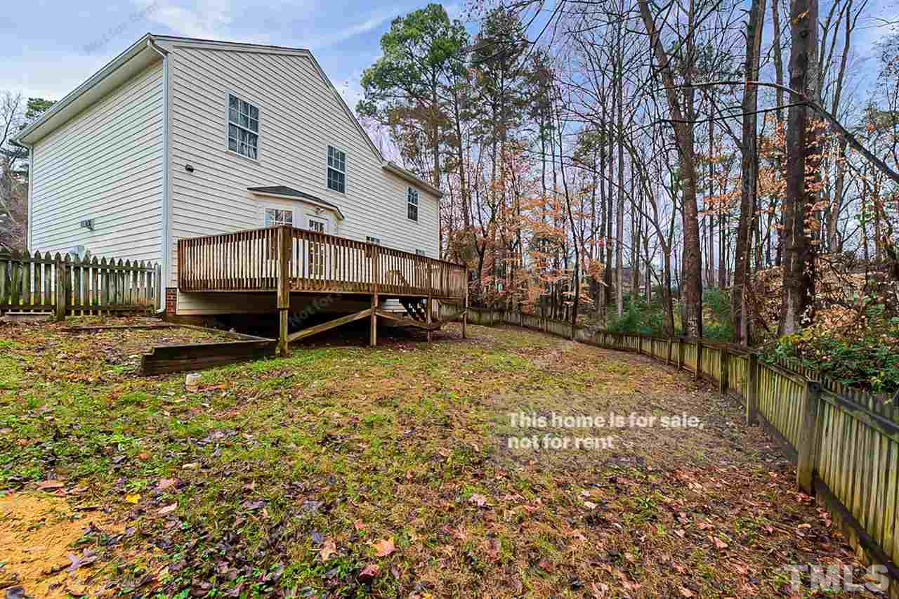8715 Harps Mill Road Raleigh, NC 27615 - Photo 22 of 22 a backyard of a house with a small yard and wooden fence