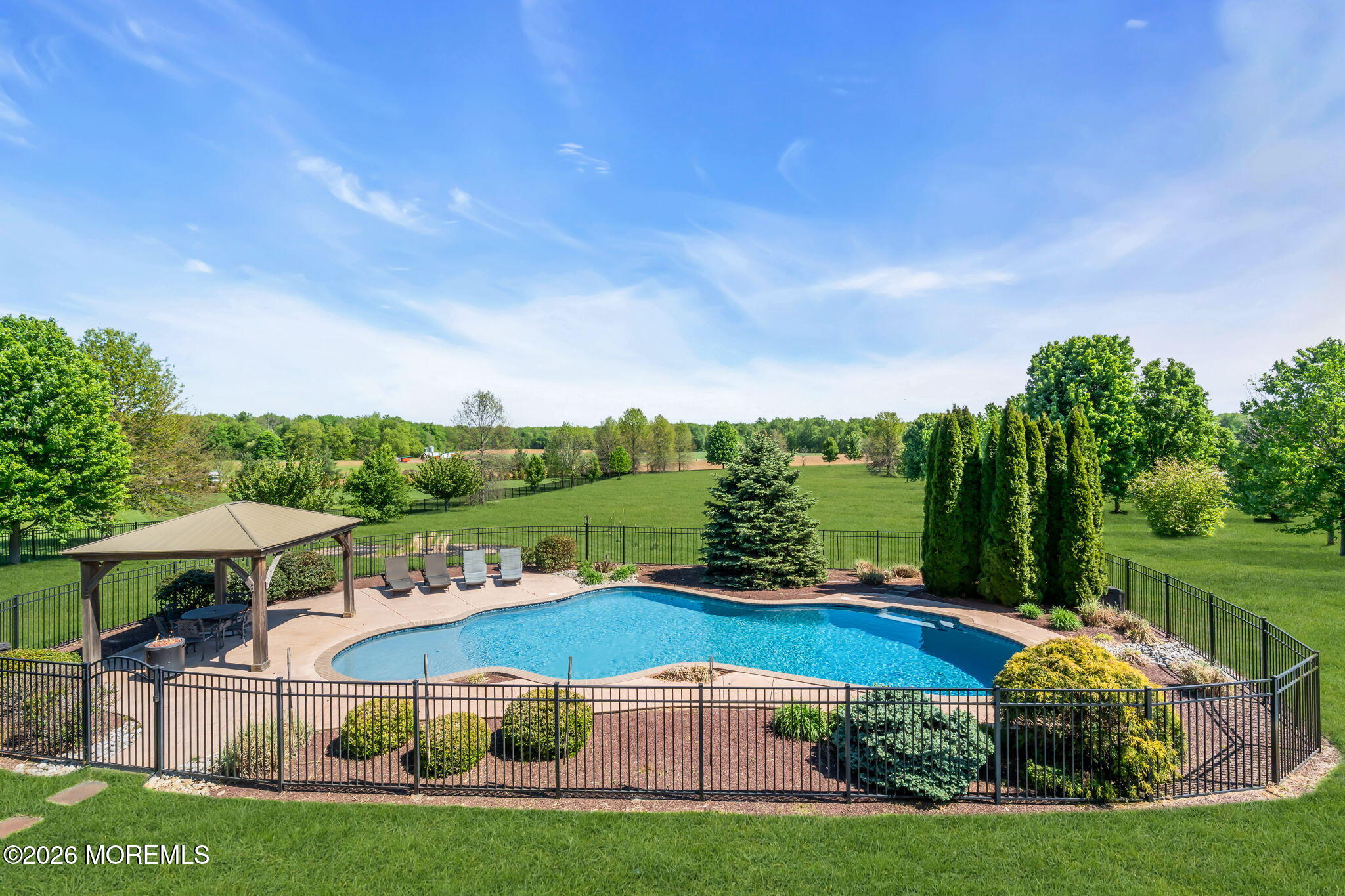 42 Ridgeview Way Allentown, NJ 08501 - Photo 42 of 47 a view of a garden with lawn chairs under an umbrella