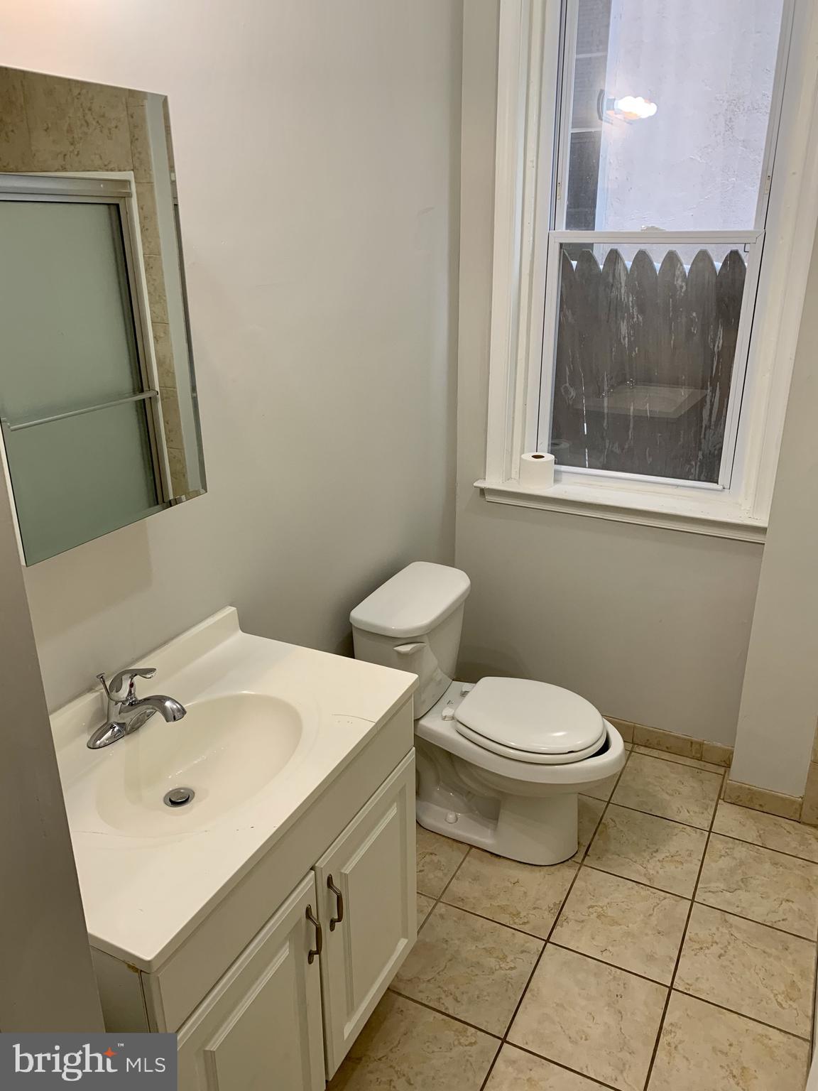 4439 Chestnut Street, Unit 1R Philadelphia, PA 19104 - Photo 11 of 22 a bathroom with a toilet sink and mirror