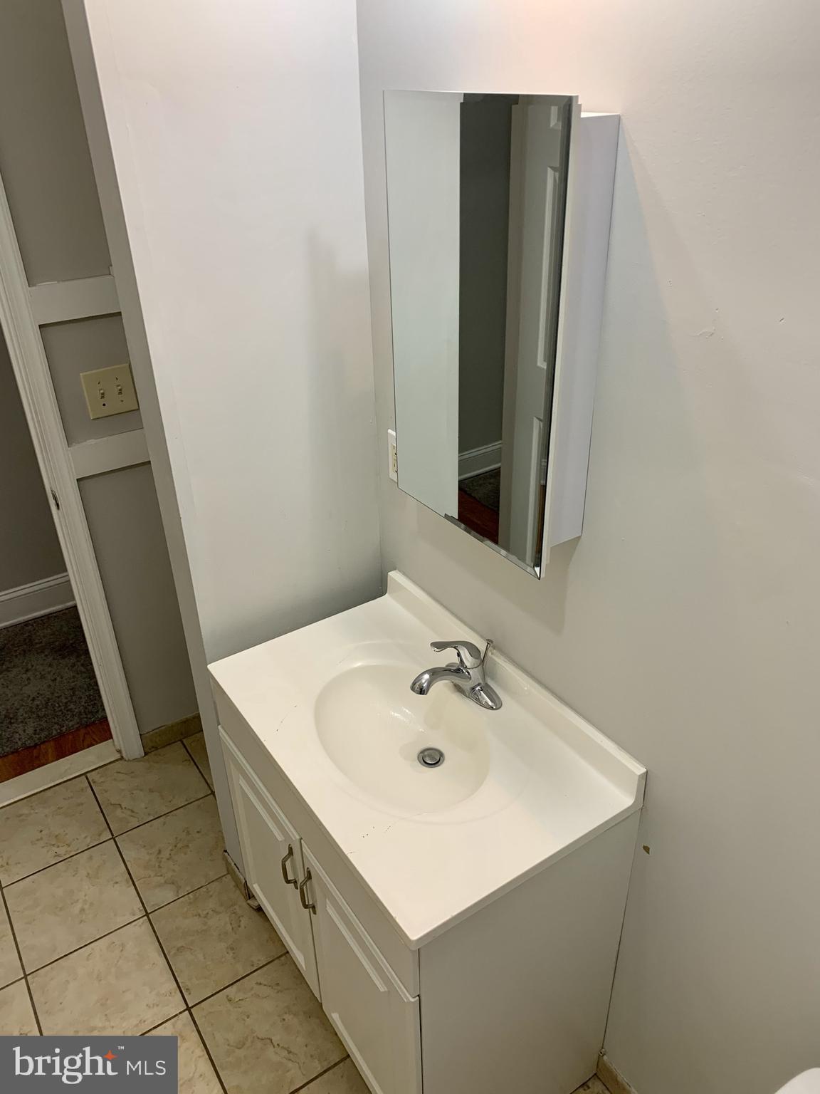 4439 Chestnut Street, Unit 1R Philadelphia, PA 19104 - Photo 12 of 22 a bathroom with a sink a toilet and mirror